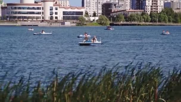 Burgers Varen Catamarans Langs Meer Water Tegen Hedendaagse Stedelijke Gebouwen — Stockvideo