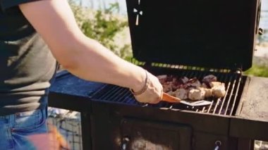 Nehir kenarındaki terasta sıcak Brezilya usulü et yiyen bir adam var. Güneşli yaz gününde açık hava yemekleri.