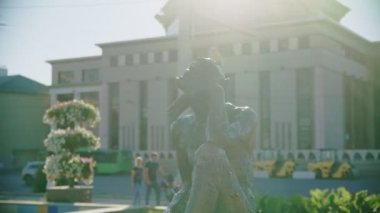 Güneşli bir günde şehir parkında halka açık binalara karşı şeytani bir heykel hayal etmek. Kare üzerinde peri masalı karakteri heykeli