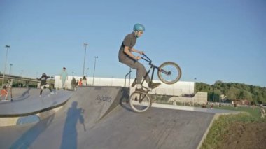 KAZAN, TATARSTAN RUSSIA - 06 Temmuz 2021: genç adam parktaki yavaş çekimde bisiklet taliminde hile yapıyor. Aktif yaşam tarzı ve boş zaman Kazan 'da Temmuz 06