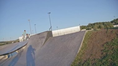 KAZAN, TATARSTAN RUSSIA - 06 Temmuz 2021: Genç çocuk scooter 'a biniyor ve şehir parkında ağır çekimde eğleniyor. Atletik adam Kazan 'da 06 Temmuz' da modern spor sahasında antrenman yapıyor.