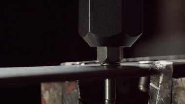 Fabrika atölyesinde ayrıntıları birbirine bağlamak için metal perçin yerleştirme işlemi. Bağlantının endüstriyel teknolojisi