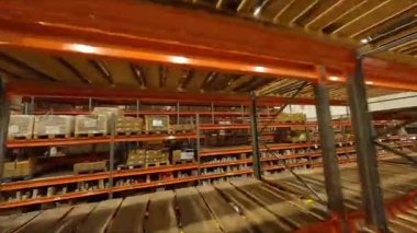 Deponun ilk bakış açısında karton kutularla rafların ve rafların arasında hareket. Malzeme deposu için ekipman