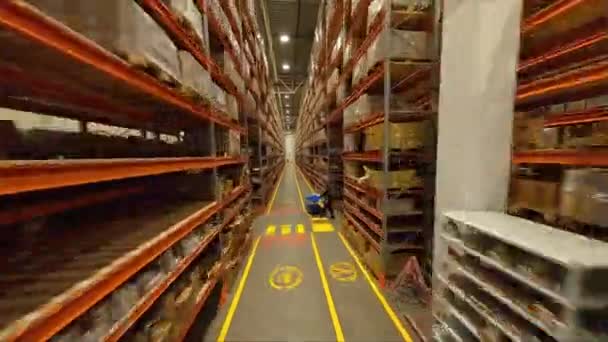パッケージと植物倉庫の最初のポイントビューで歩行労働者と高棚の間の通路 製品の工場保管 — ストック動画