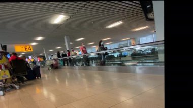 Amsterdam Hollanda 11 Kasım 2021: Schiphol Havaalanı. Koruyucu maskeli insanlar havaalanı koridorunda uçmak için yürüyorlar.