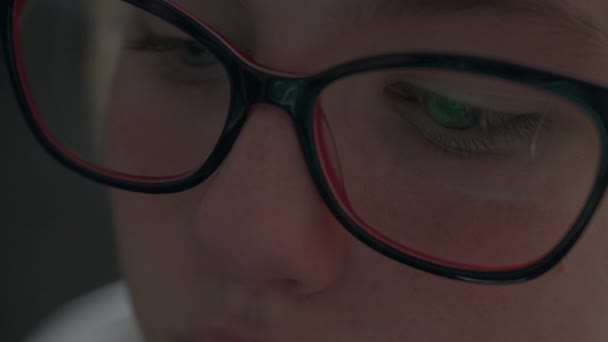 一个戴眼镜的女生聚精会神地望着显示屏 镜面上有倒影 使用电脑时戴上电脑眼镜以减少眼部疲劳 — 图库视频影像