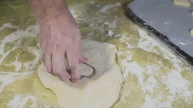 Baker, ev ortamında taze hamur kalıplarıyla kurabiyeleri keser.