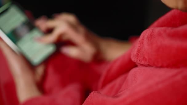 一个穿着红色外套的女人在手机上用黑色背景的网络拍的特写镜头 选择性焦点 — 图库视频影像