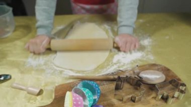 Baker masanın üzerinde merdaneyle hamuru yuvarlıyor. Seçici Odaklanma 