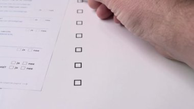 Bir el kırmızı bir kalem tutar ve bir soru listesi doldurur