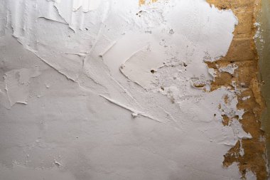 Endüstriyel geçmiş. Duvarda yapısal alçı var. Alçı lekeli tuğla duvar