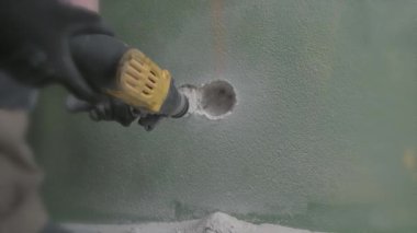 Kaya matkabı işi. Beton duvarda sondaj deliği. Kapat.