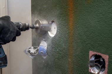 Kaya matkabı işi. Beton duvarda sondaj deliği.