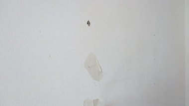 Close-up shoot. Plasterer puttying holes in the wall