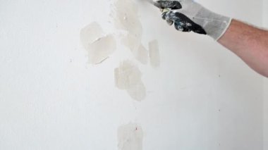 Close-up shoot. Plasterer puttying holes in the wall