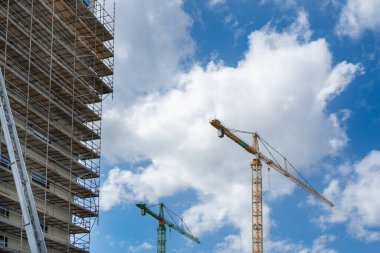 Kule vinçleri dramatik bir gökyüzüne karşı. İnşaat alanı