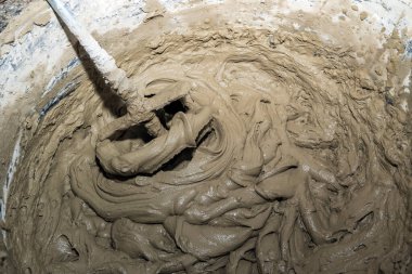Industry background. Construction site. Mixing tile adhesive with a construction mixer