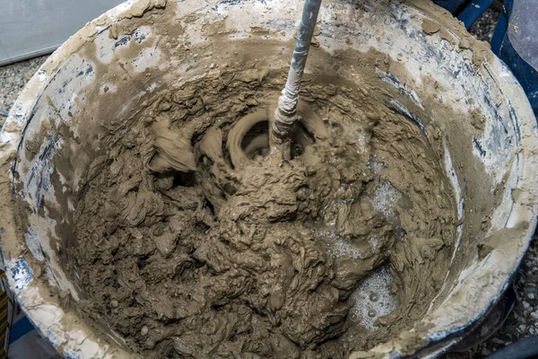 Industry background. Construction site. Mixing tile adhesive with a construction mixer