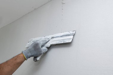 Plasterer applies plaster on the wall during repair and restoration work. Leveling the wall with a spatula. 