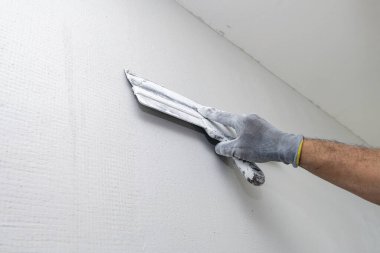 Plasterer applies plaster on the wall during repair and restoration work. Leveling the wall with a spatula. 