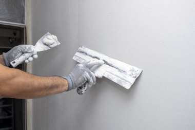 Plasterer applies plaster on the wall during repair and restoration work. Leveling the wall with a spatula. 