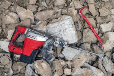 Seçici odaklanma. Levye ve kaya matkabı, büyük kırık beton duvarlar ve yapının yapısal elementleri üzerine kuruludur..