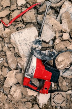 Seçici odaklanma. Levye ve kaya matkabı, büyük kırık beton duvarlar ve yapının yapısal elementleri üzerine kuruludur..