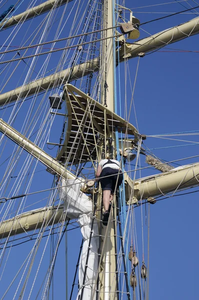 Marin travaillant dans le gréement d'un voilier — Photo