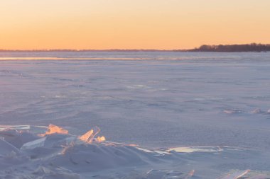 Nehir manzarasının karlı kıyısında. Kış kar sahnesi. Karda kış nehri. Mırıldanmalar. Bir buz yığını..