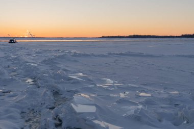 Nehir manzarasının karlı kıyısında. Kış kar sahnesi. Karda kış nehri. Mırıldanmalar. Bir buz yığını..