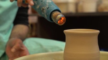 Çömlekçi çömlek çarkında çalışıyor. Çamur kaseleri yumuşak renkli çamurdan.
