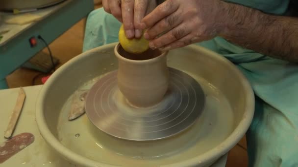 El alfarero trabaja en una rueda de cerámica. Cuencos de arcilla hechos de arcilla de color suave — Vídeos de Stock