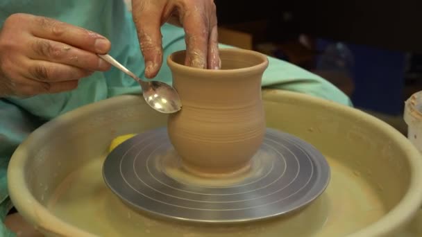 El alfarero trabaja en una rueda de cerámica. Cuencos de arcilla hechos de arcilla de color suave — Vídeo de stock