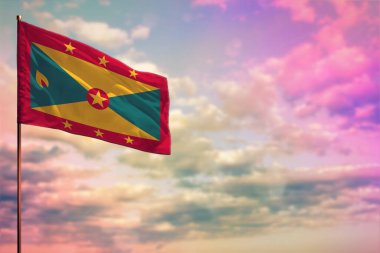 Renkli bulutlu gökyüzü arkaplanı üzerine yazdığınız metin için yer ile dalgalanan Grenada bayrağı.