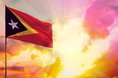 Sol üst köşede dalgalanan Timor-Leste bayrağı. Rengarenk günbatımı ya da gündoğumu arkaplanı hakkında bilgi almak için yeriniz hazır..