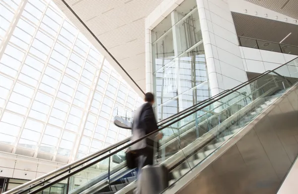 Un homme flou monte l'escalator. — Photo