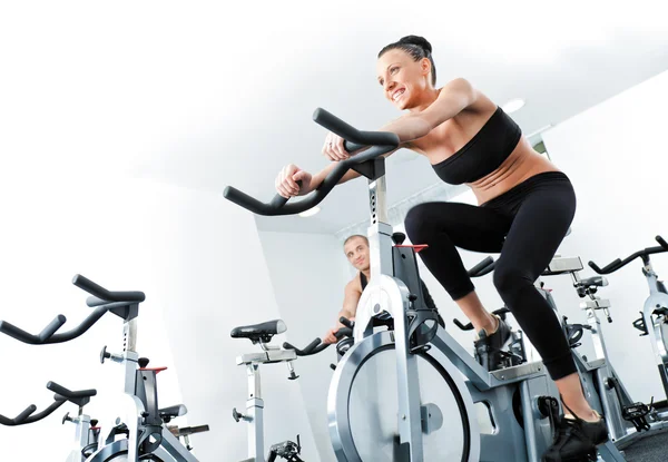 Vrouw veloargometer gim fitness — Stockfoto