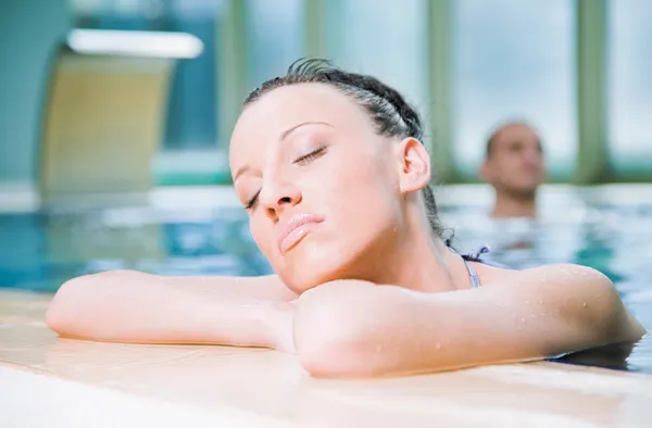 Kvinne som slapper av i svømmebassenget – stockfoto