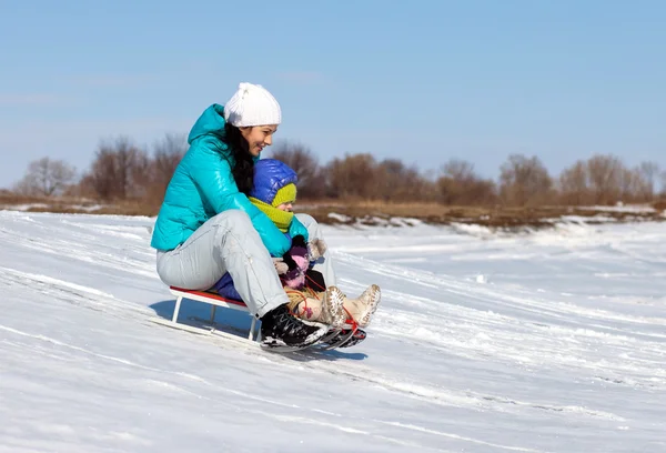 妈妈和女儿骑在雪橇上 — 图库照片