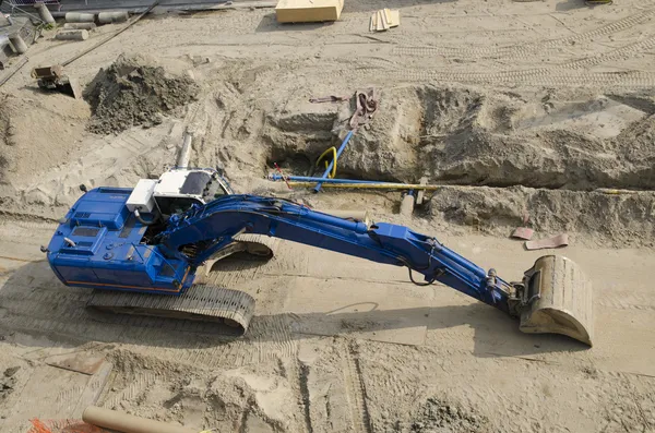 Excavadora azul en el sitio de la constucción Imagen de archivo