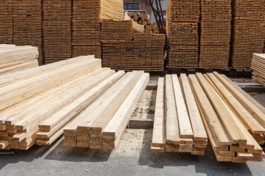 Endüstriyel bir sitede sıralanmış. Arka planda kereste üretimi.