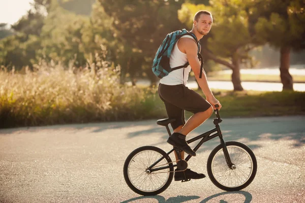 Jovem sentado em bicicleta esportiva — Fotografia de Stock