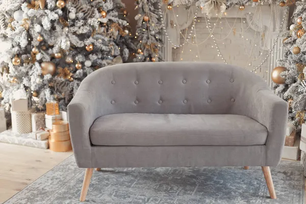 Saalausstattung mit Sofa, Kamin mit Kerzen und geschmücktem Weihnachtsbaum mit Geschenken. Großer Designer-Schneebaum im Aufenthaltsraum mit Lichtern und Kugeln in beige, braun, gold und silber. — Stockfoto