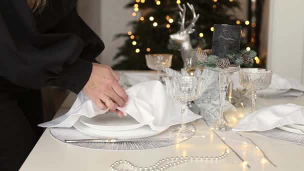 Tutoriel vidéo comment envelopper une serviette tissée sur une assiette pour un cadre de table magnifique pour le dîner de vacances. Mains de femme décorant et servant table de fête pour les vacances de Noël. — Video