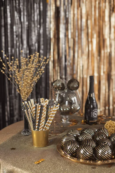 Feestelijke decoraties op tafel zetten in zwart en goud kleuren om het nieuwe jaar en kerstfeest te vieren — Stockfoto