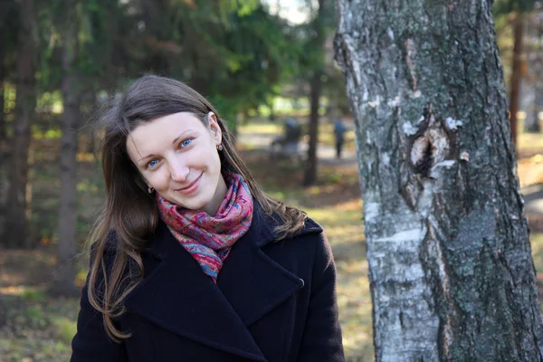 Vacker flicka i en park på höst-dagen — Stockfoto