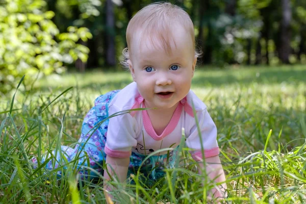 Счастливая маленькая девочка в парке на траве — стоковое фото