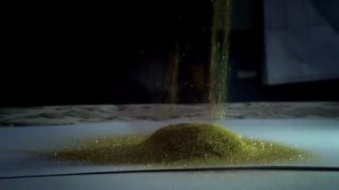 Altın parıltılı kum ya da toz soyut bulut oluşumları başkalaşımı yaratıyor. Sanat arkaplanı.