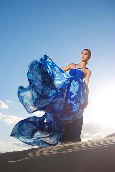 Çöl üzerinde mavi elbiseli güzellik kadın — Stok fotoğraf