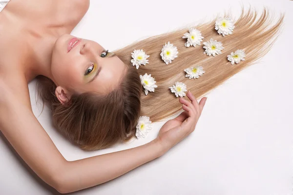 Jovem mulher atraente deitada coberta de flores — Fotografia de Stock